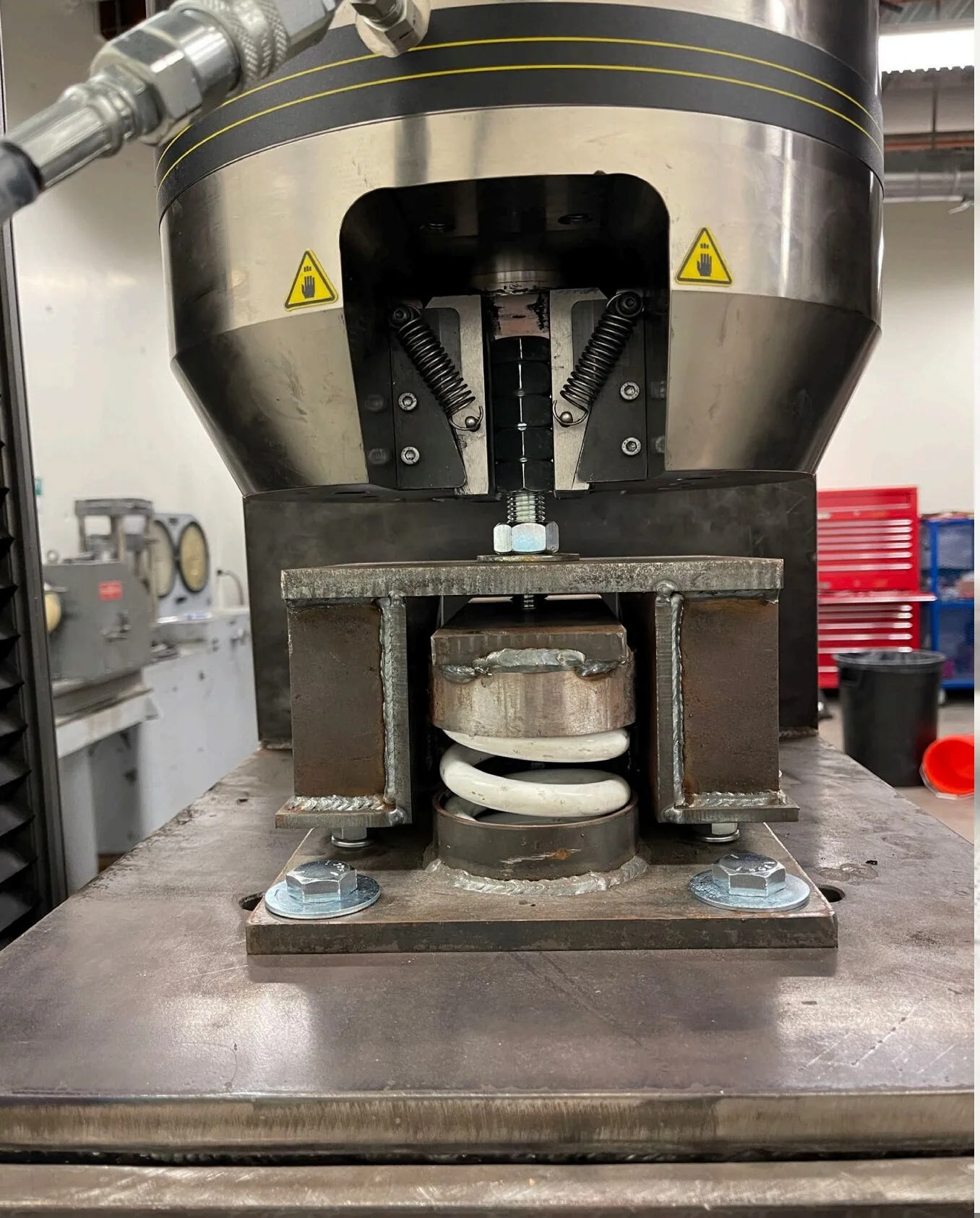 Single SSI isolator mounted in a universal testing machine during uniaxial tension test to failure at the University of Nevada, Reno